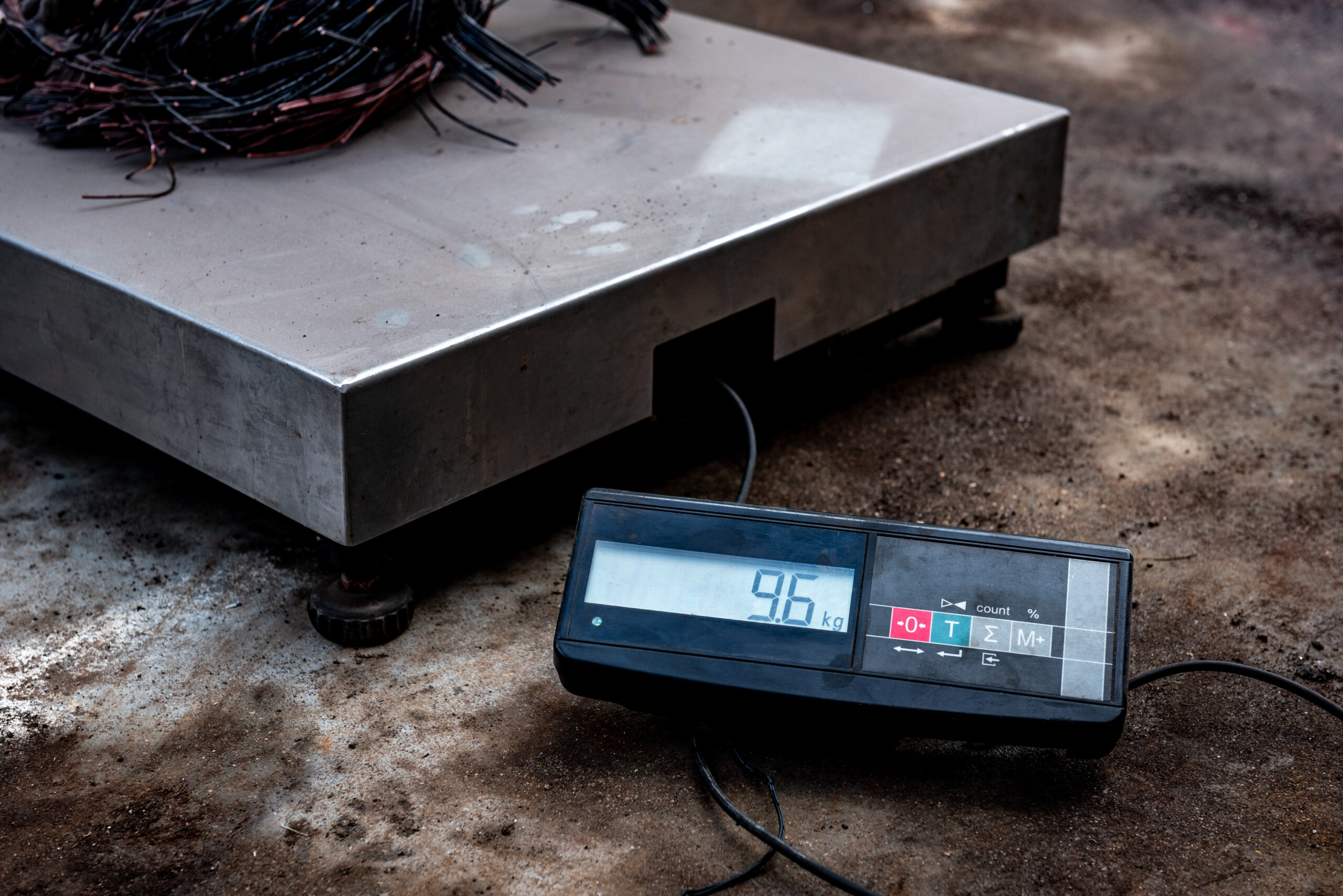 stainless steel platform scale on the ground weighing products with separate digital screen displaying a weight of 9.6 kilograms